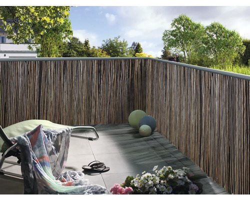 Balkon mit Sichtschutz aus Naturmaterialien, Liegestuhl und Dekoration