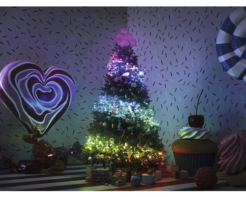 Dekorierter Weihnachtsbaum mit Süßigkeiten und Geschenken in einer verspielten Umgebung.