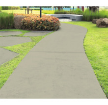Gartenweg aus Betonplatten, umgeben von Gras und Pflanzen
