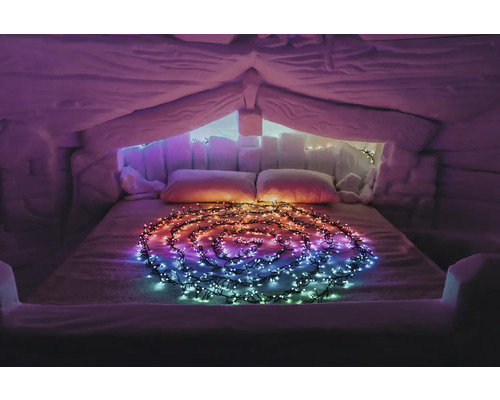 Innenraum eines Iglus mit Bett und Lichterkette