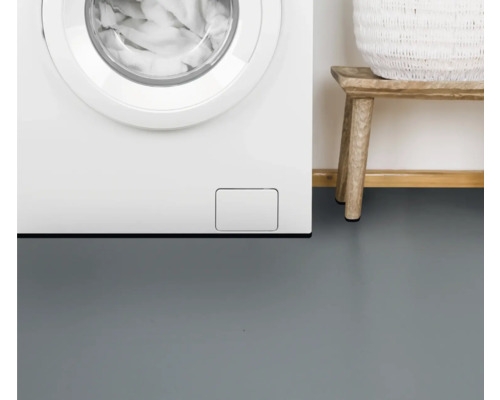 Detailaufnahme einer Waschmaschine, eines Holzschemels und eines Wäschekorbs im Badezimmer