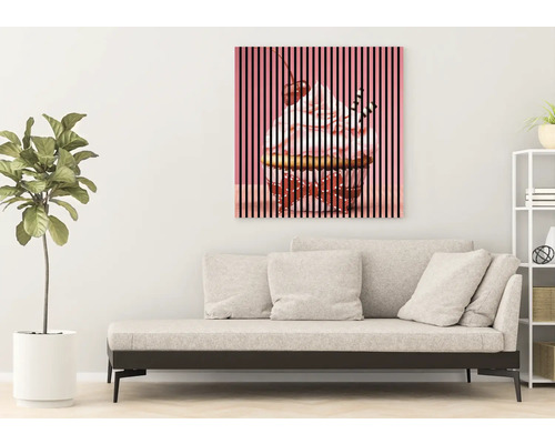 Dekorative Leinwand mit Cupcake-Motiv über einem Sofa in einem Wohnzimmer.