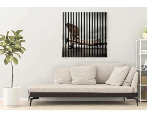 Wohnzimmer mit Sofa und Wandbild mit Flugzeugmotiv