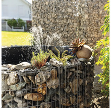 Gabionenbrunnen mit Steinen, Pflanzen und Wasserspiel im Garten