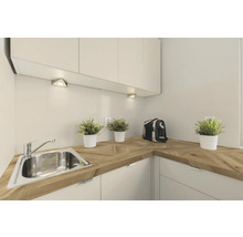Küchenszene mit Spüle, Arbeitsplatte aus Holz, Küchenschränken und Beleuchtung