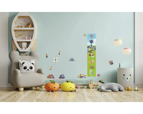 Kinderzimmer mit Sessel, Regal, Spielzeug und Wandstickern mit Paw Patrol Motiven.