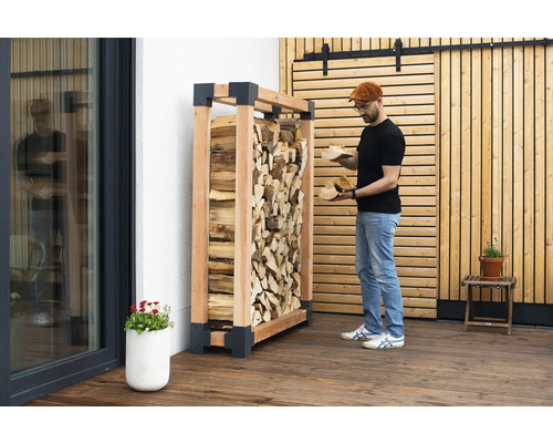 Holzlagerregal aus Holz mit Brennholz und einer Person, die Holz hält