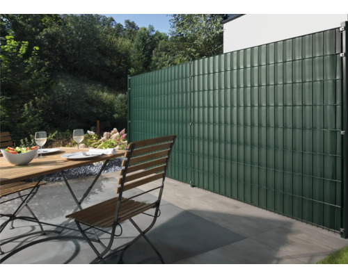 Garten mit Doppelstabmattenzaun, Gartentisch und Stühlen auf der Terrasse