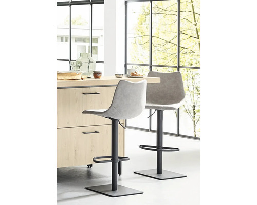 Zwei Barhocker vor einer Küchentheke in einem hellen Raum.