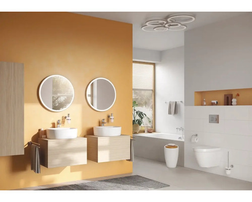 Badezimmer mit Waschtischen, runden Spiegeln, Toilette und Badewanne