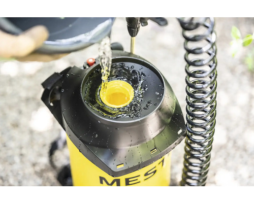 Befüllung einer gelben Gartenspritze der Marke Mesto mit Flüssigkeit