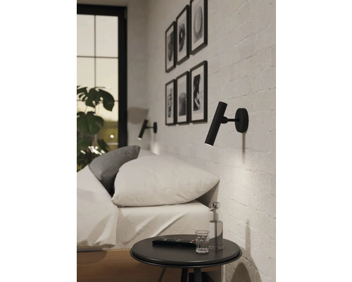 Schlafzimmer mit Bett, Nachttisch und zwei Wandleuchten