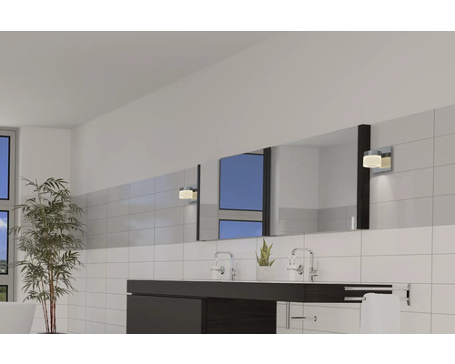 Helles Badezimmer mit Waschtisch, Spiegel, Wandleuchten und Pflanzen