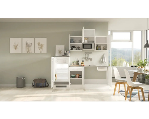 Kompakte Küche mit Kühlschrank, Spüle, Mikrowelle und Stauraum in einem hellen Raum.