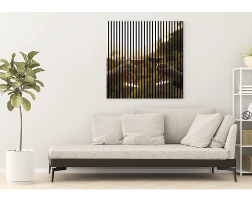 Wohnzimmer mit Sofa und gerahmtem Bild mit vertikalen Streifen, das zwei anstossende Weingläser zeigt.