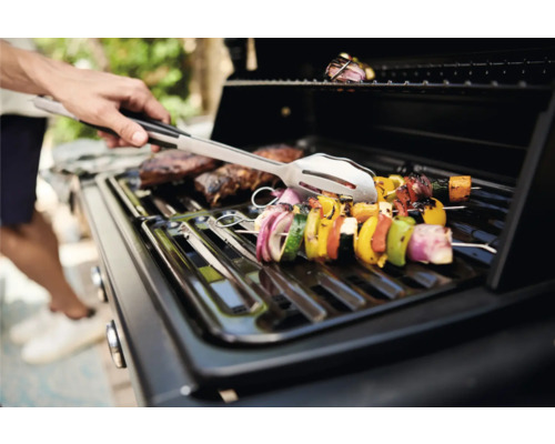 Grill mit Grillgut und Grillzange