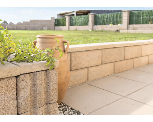 Gartenmauer aus Betonsteinen mit dekorativer Amphore