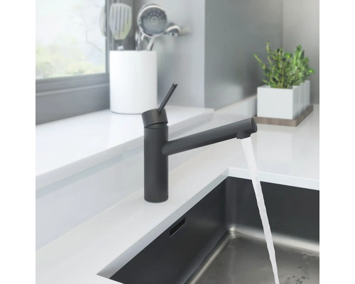 Schwarze Küchenarmatur mit fließendem Wasser in einem modernen Küchendesign.