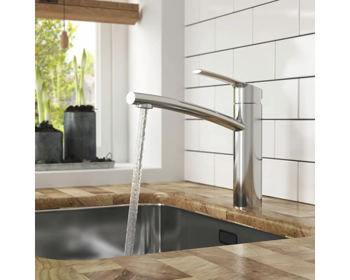 Küchenszene mit einer Armatur aus Metall und fließendem Wasser in einem Spülbecken