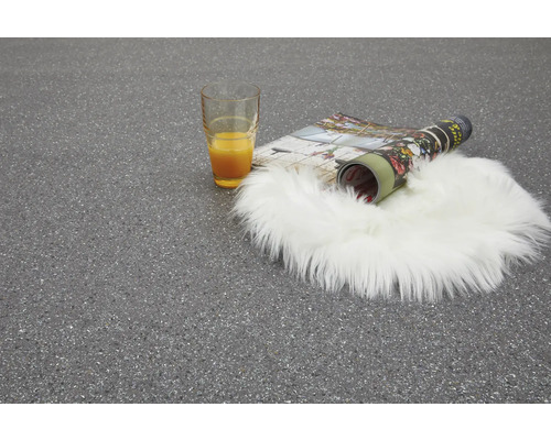 Szene mit Glas Orangensaft, Zeitschrift und Schaffellteppich