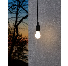 Hängelampe mit Glühbirne vor einer Wand