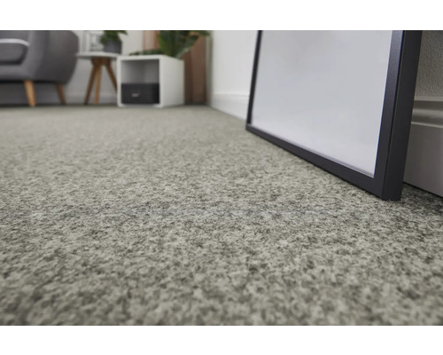 Nahaufnahme eines grauen Teppichs in einem Wohnraum.