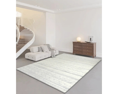 Wohnzimmer mit Sofa, Kommode und einem hellen Teppich mit Muster