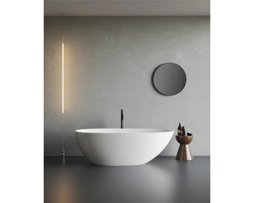 Modernes Badezimmer mit freistehender Badewanne, rundem Spiegel und minimalistischer Beleuchtung