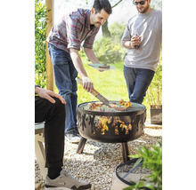 Personen grillen auf einem Holzkohlegrill im Garten.
