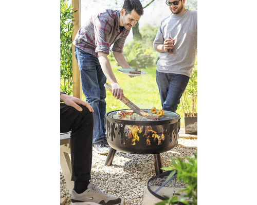 Personen grillen auf einem Holzkohlegrill im Garten.