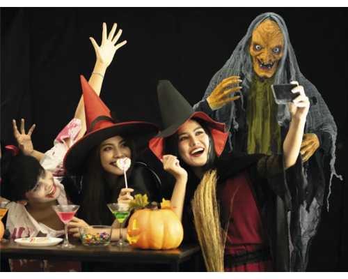 Halloween Party mit Hexen, einer Dekofigur und Süßigkeiten.