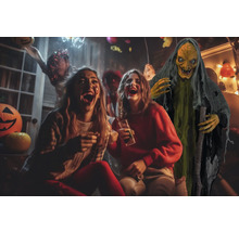Szene einer Halloweenparty mit lachenden Personen und einer Hexenattrappe.