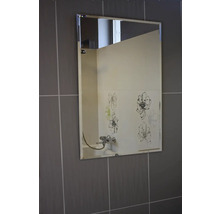 Rechteckiger Spiegel an einer Wand mit Fliesen