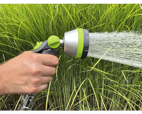 Eine Hand hält eine Gartenspritze, die Wasser versprüht.