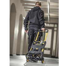 Mann transportiert Treppensteiger-Sackkarre von Stanley in einem Gebäude