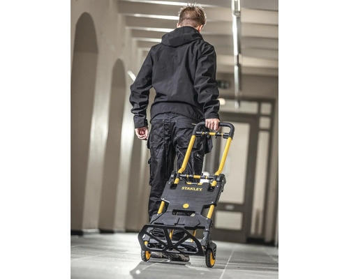 Mann transportiert Treppensteiger-Sackkarre von Stanley in einem Gebäude