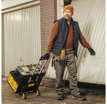 Handwerker mit Werkzeugwagen vor einer Garage