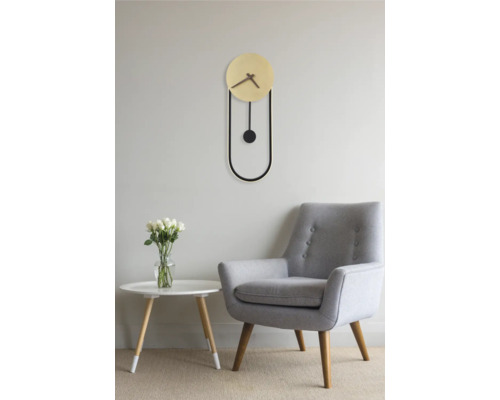 Wohnzimmer mit Pendeluhr, Sessel und Tisch mit Blumen