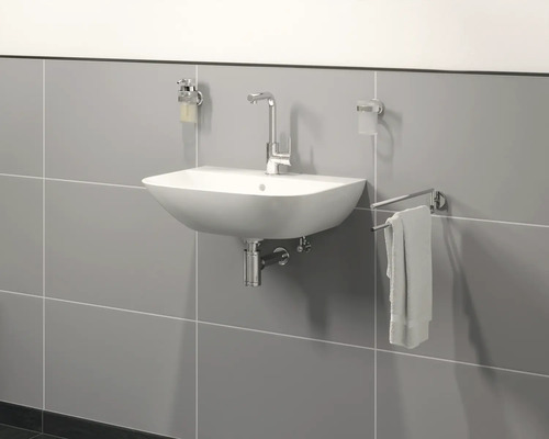 Badezimmer Waschbecken mit Armatur, Seifenspender, Zahnputzbecher und Handtuchhalter an einer gefliesten Wand