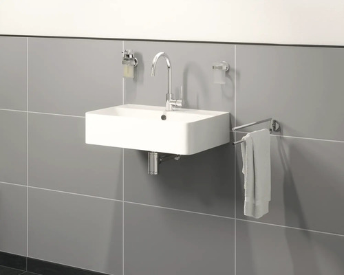 Waschbecken im Badezimmer mit Armatur, Seifenspender, Handtuchhalter und Zahnputzbecher