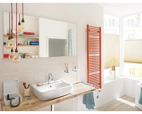 Badezimmer mit Waschbecken, Spiegel, Heizkörper und Beleuchtung