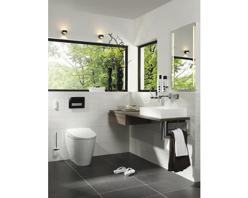 Helles Badezimmer mit Toilette, Waschbecken, Spiegel und großem Fenster