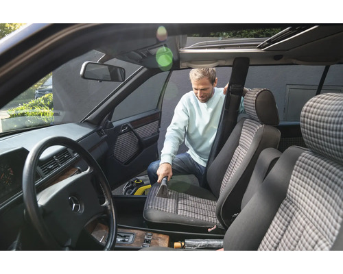 Mann reinigt Autositz mit Polsterreiniger