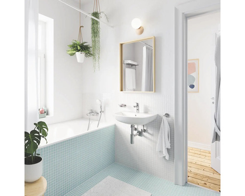 Badezimmer mit Badewanne, Waschbecken, Spiegel und Pflanzen