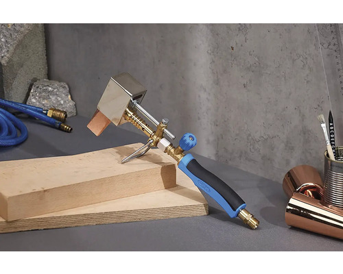 Dachbrenner mit Schlauch und Holz auf grauem Untergrund