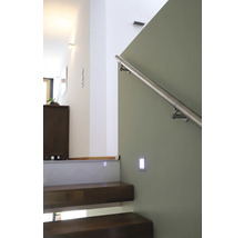 Treppenhaus mit Holzstufen, Edelstahlgeländer und Wandleuchte