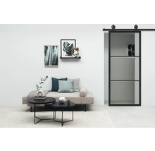 Wohnzimmer mit Sofa, Couchtischen, Wandbildern und Schiebetür