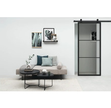 Wohnzimmer mit Sofa, Couchtischen, Wanddekoration und Glasschiebetür
