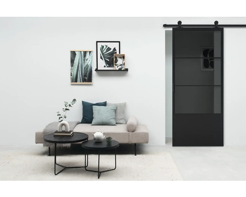 Wohnzimmer mit Sofa, Couchtischen, Wanddekoration und Schiebetür