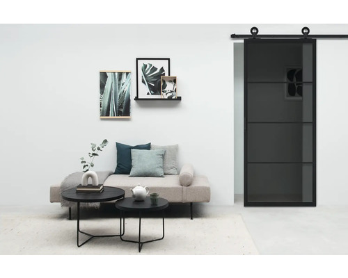 Wohnzimmer mit Sofa, Couchtischen, Wanddekoration und Glasschiebetür